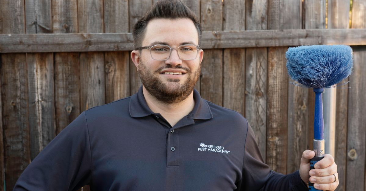 Griffin Thomas, owner of Preferred Pest Management, holding pest control tool in Plano TX